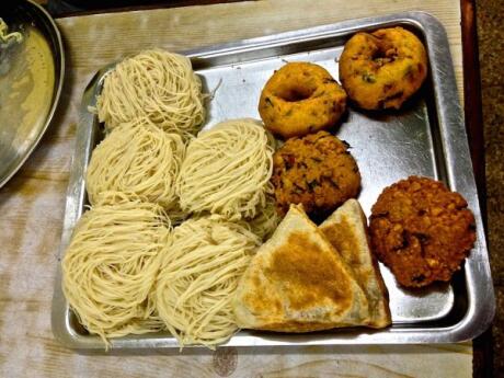 A plate of string hoppers, vegetable rotis and various vadai snacks from Sri Lanka