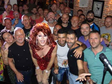 Seby and Stefan posing with a drag queen and the audience at El Piano gay bar in Sitges.