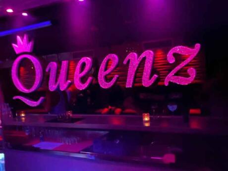 The pink illuminated "Queenz" logo at Queenz gay bar in Sitges.