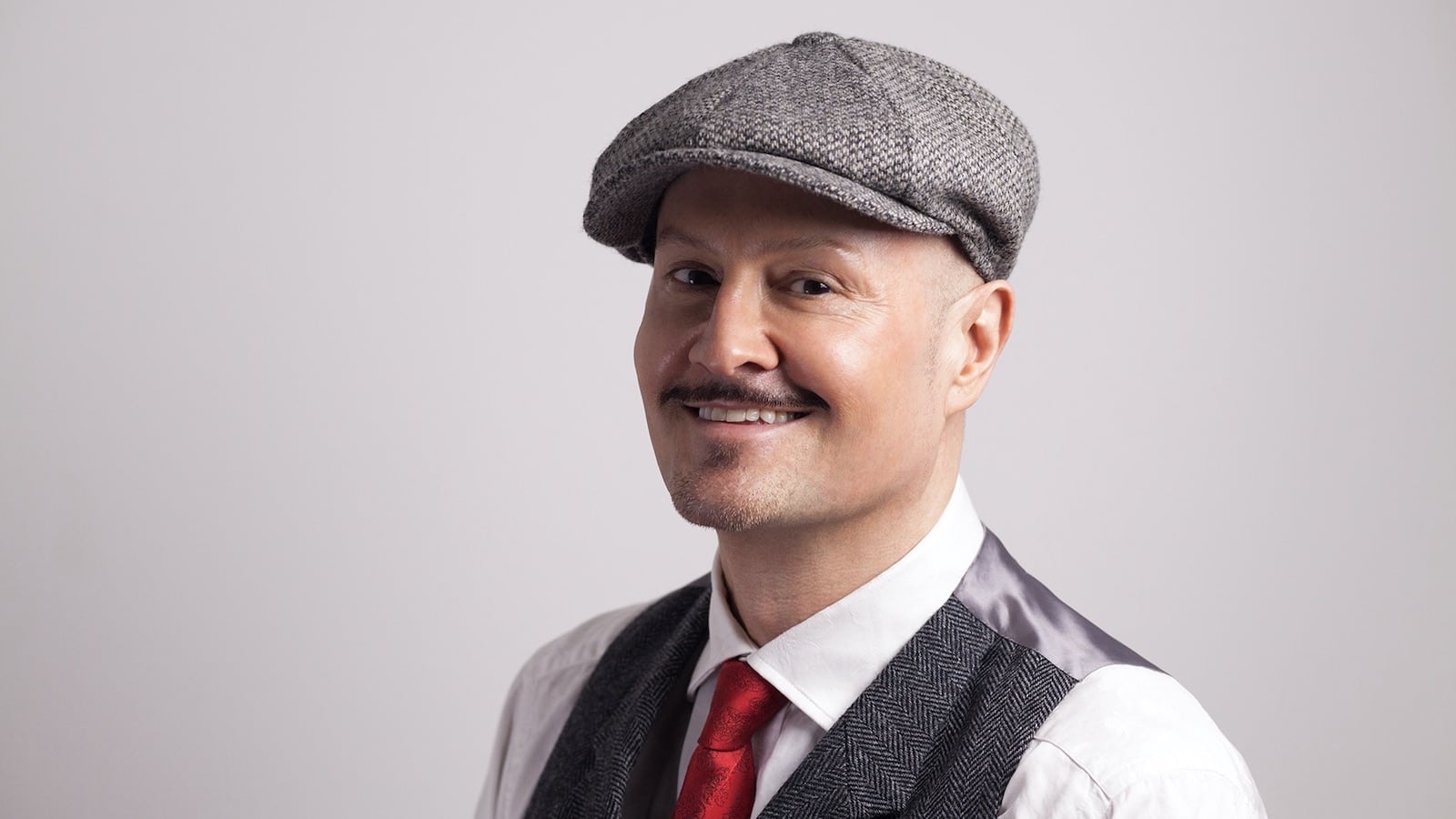 A portrait photo of Paul Burston gay author smiling happily to the camera. 