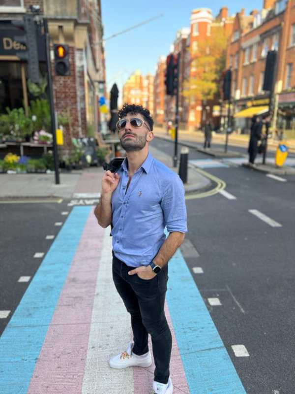 Stefan Arestis from Nomadic Boys walking on the trans flag zebra crossing in London.