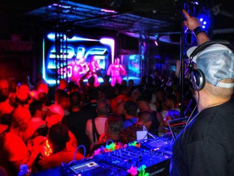 Dancers on stage plus a crowd watching in front of the DJ at Alibi gay club in Rome.