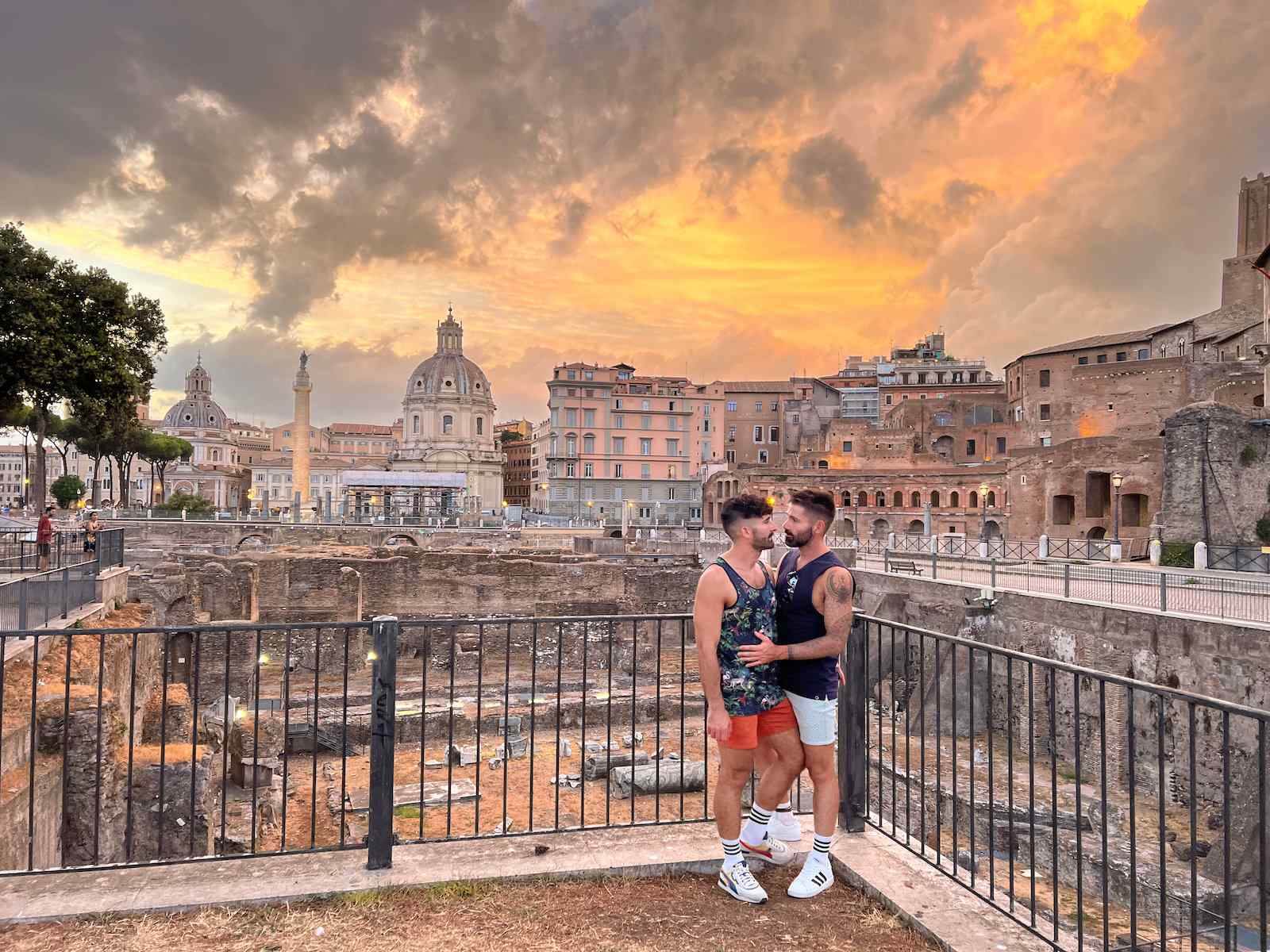 The Nomadic Boys sharing a kiss in front of the Roman Forum and an incredible sunset in Rome.