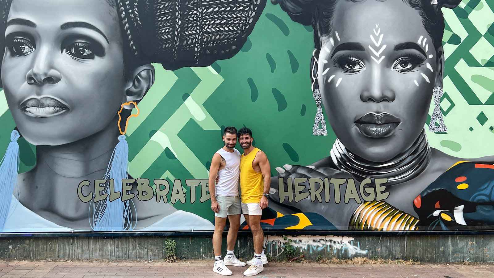 Seby and Stefan of Nomadic Boys standing in front of a mural of two beautiful African women in Johannesburg.