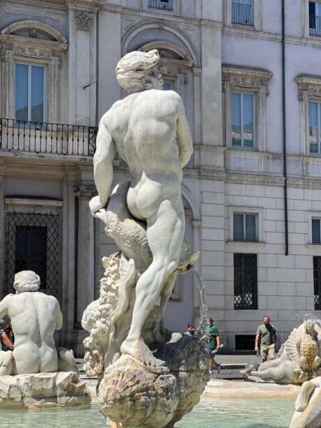 A nude man statue/water fountain at Piazza Navona in Rome on a sunny day.