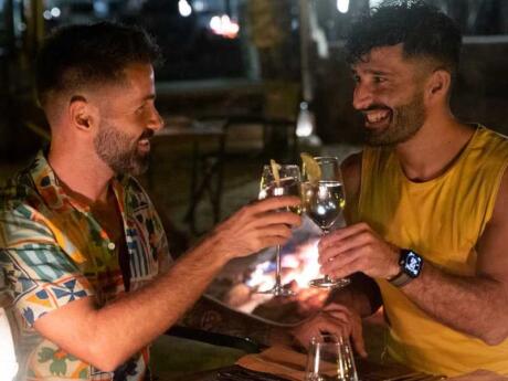 Nomadic Boys clinking their glasses together and smiling at each other in Johannesburg