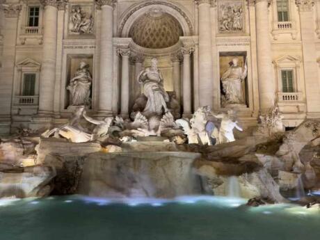 The stunning Trevi Fountain of Rome illuminated at night.